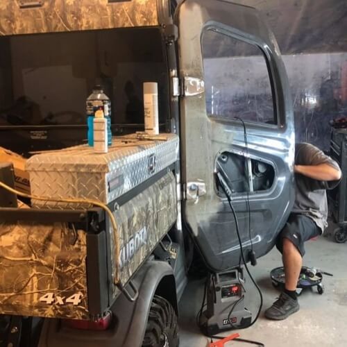 Wait! Read This ...Before You Schedule Custom Auto Work with Accelerate Auto Repair in Rowlett, TX; image of mechanic at shop doing custom work to the door of Kubota atv that came in shop for customizations