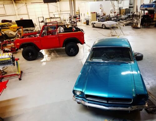 Careers at Accelerate Auto Repair in Rowlett, TX. image of aerial view of inside the shop with turquoise 70's mustang, red off road jeep and other cars being maintained 