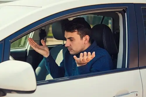 Common Problems of Late Model Cars | Accelerate Auto Repair in Rowlett, TX. Image of a young man driver, pissed off shaking hands and shrugging shoulders with his problems with the car.