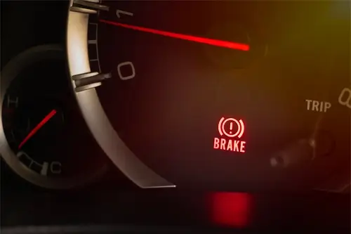 4 Easy-to-Spot Sensory Signs You Need Brake Repair | Accelerate Auto Repair in Rowlett, TX. Closeup image of an illuminated brake warning light on a dashboard.