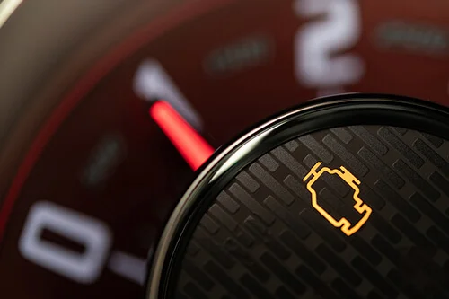 My Check Engine Light is On - What Should I Do? | Accelerate Auto Repair in Rowlett, TX. Closeup image of a yellow check engine Light on a vehicle dashboard.