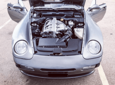 Image of a silver porsche with hood up exposing the engine that came into Accelerate Auto Repair in Rowlett Tx for services