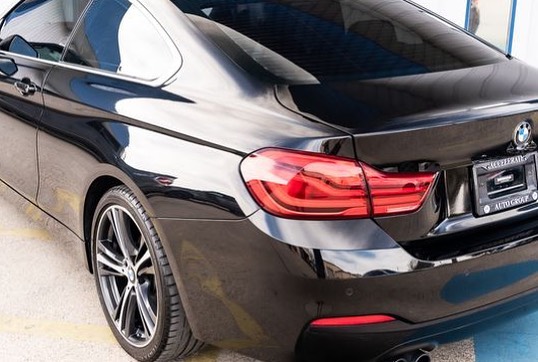 Back left side of a black BMW at Accelerate Auto Repair