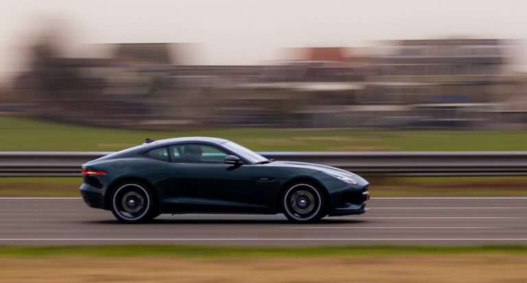 Dark sports coupe cruising on a highway with motion blur