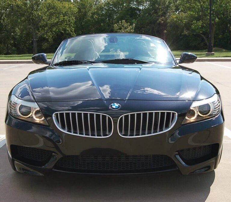 The front of a black BMW Z4 roadster parked outside.