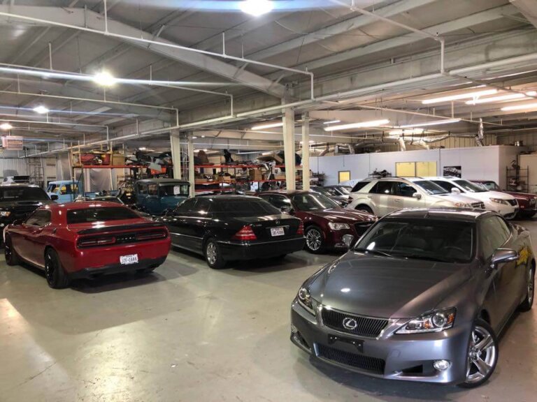 Cars parked inside a large repair shop building.