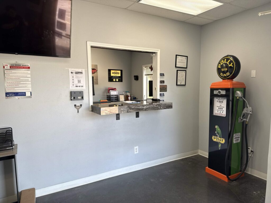 The customer waiting area at Accelerate Auto Repair in Rowlett, Texas, with the service window and the AAA Approved Auto Repair member-benefits notice on the wall.
