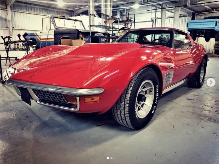 A red classic Chevrolet Corvette parked inside a shop.