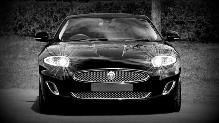 A black-and-white photo of the front of a Jaguar sports car.