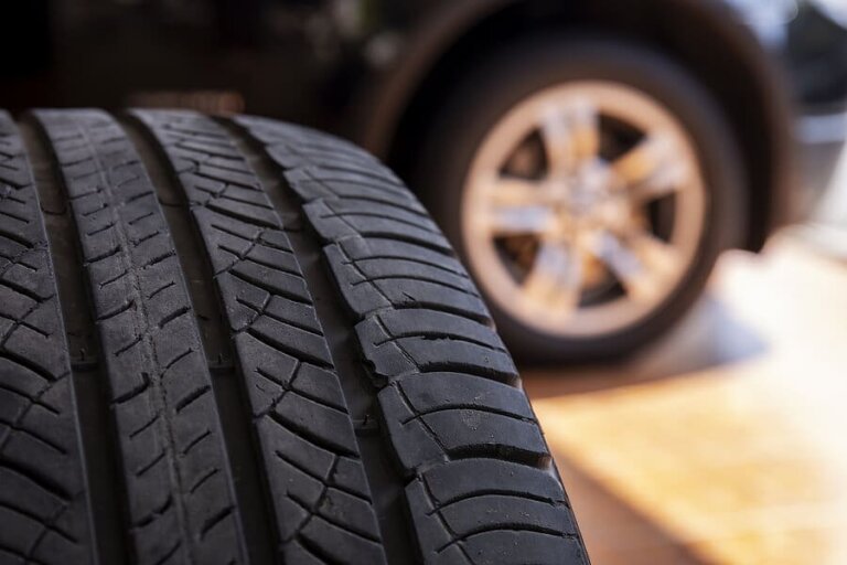 A close-up of a car tire with worn tread.