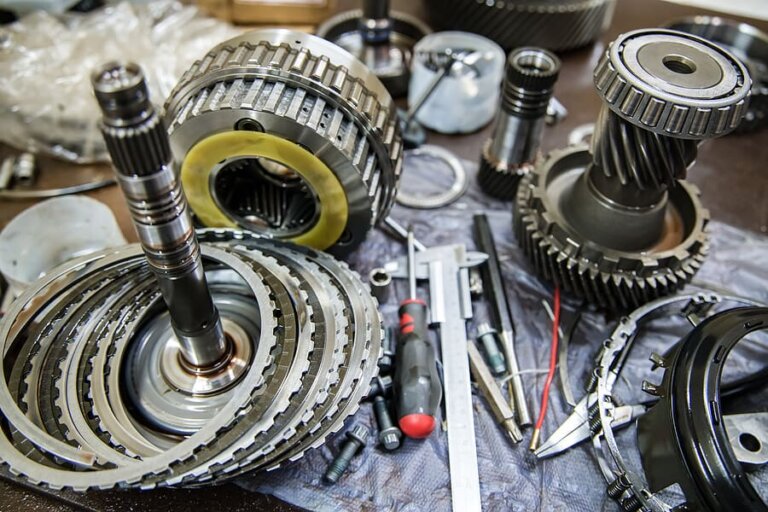Automatic transmission clutch packs, shafts and gear assemblies arranged on a workbench.