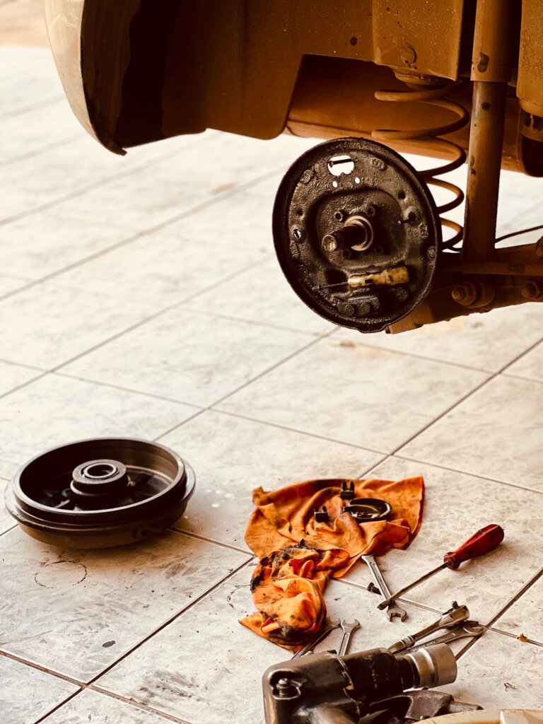 Brake rotor and hub parts removed during a repair on a garage floor