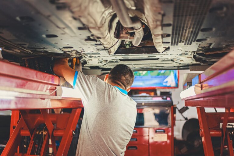 Mechanic working under a car raised on a lift