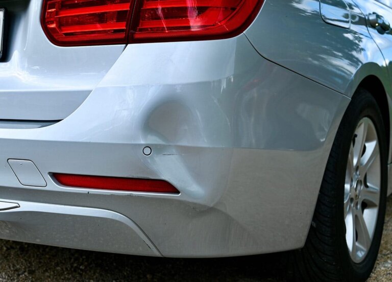 Rear bumper and side panel of a silver car.