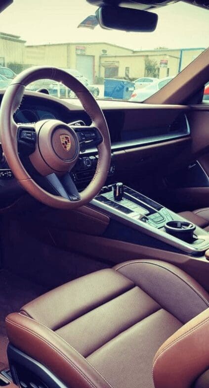 A vehicle interior with the driver seat, steering wheel and center console.