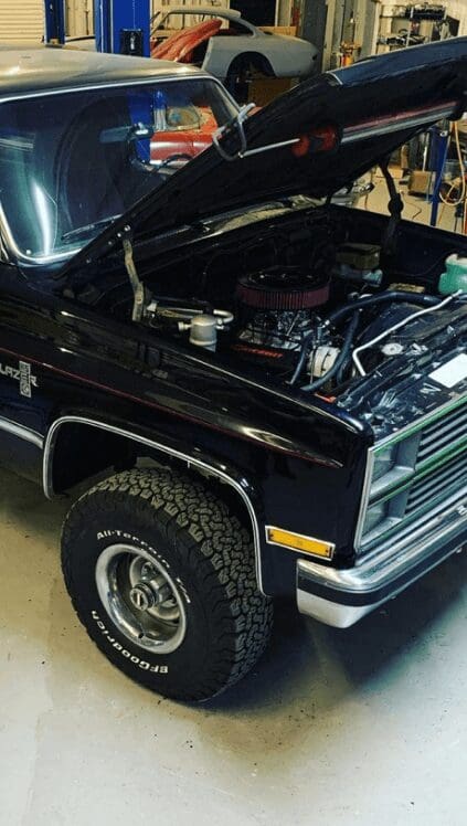 A pickup truck with its hood open.